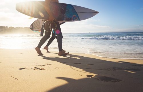 Surfer australia gold coast Australian surfers guys walking along Bondi Beach with surboards and sun flare