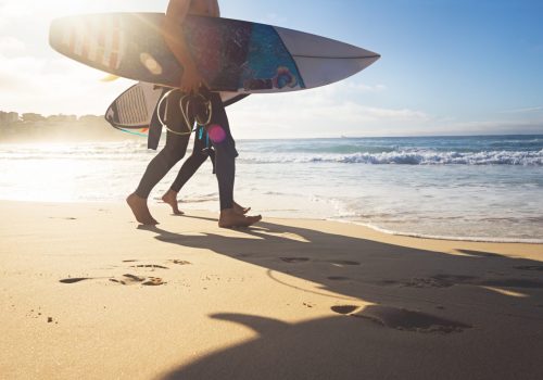 Surfer australia gold coast Australian surfers guys walking along Bondi Beach with surboards and sun flare