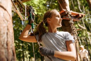 Ragazza intenta in un percorso avventuroso a Monte Baldo durante il programma Adventure