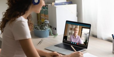 utilizzo computer scuola Smiling woman watch webinar on computer at home study online with teacher or tutor. Happy female employee talk on video call, have webcam digital virtual conference with colleague on laptop.
