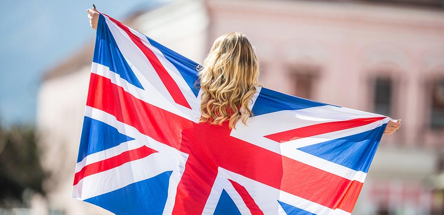 Attractive happy young girl with the flag of the Great Britain.