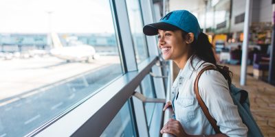 Young woman at airport waiting for airplane Young woman at airport waiting for airplane