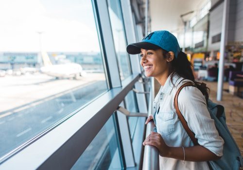 Young woman at airport waiting for airplane Young woman at airport waiting for airplane