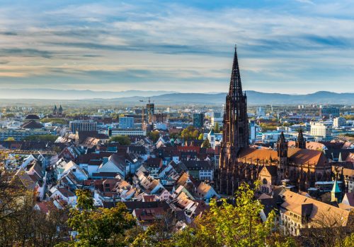 Germany, XXL panorama of city freiburg im breisgau skyline with cathedral muenster in old town in warm sunset light in romantic autumn season, aerial view above cityscape